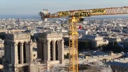 GreenPeace installe une banderole sur la grue de Notre-Dame de Paris GreenPeace installe une banderole sur la grue de Notre-Dame de Paris